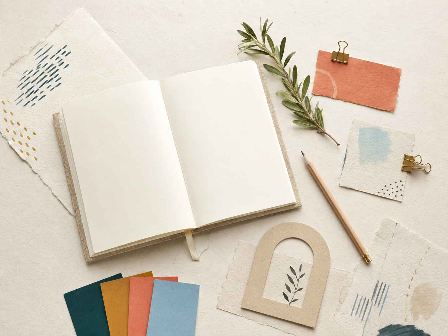 Mesa de trabajo editorial con cuaderno abierto, papeles, lápiz y muestras de color